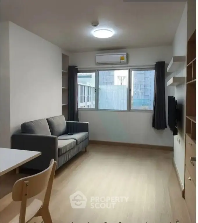 Modern living room with cozy sofa and large window offering city view, perfect for urban living.