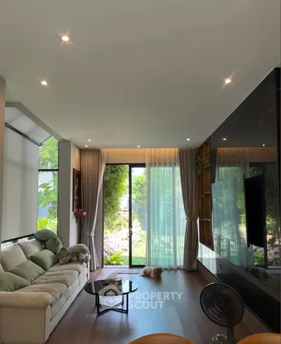 Modern living room with large window, cozy sofa, and stylish decor