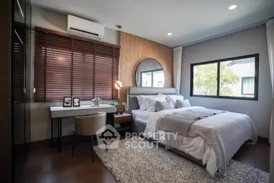 Modern bedroom with stylish decor, featuring a cozy bed, elegant desk, and large window view.