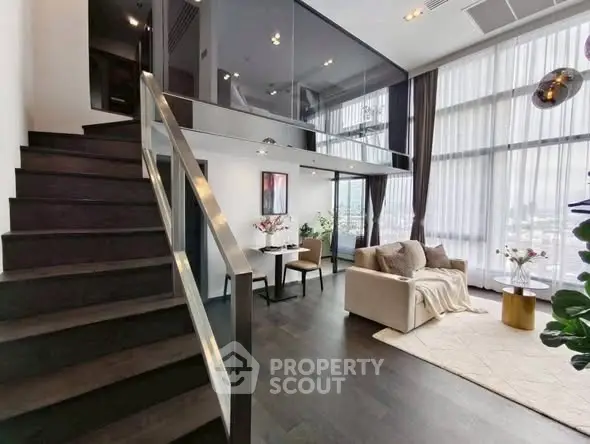 Luxurious modern living room with high ceilings and mezzanine, featuring elegant decor and large windows.