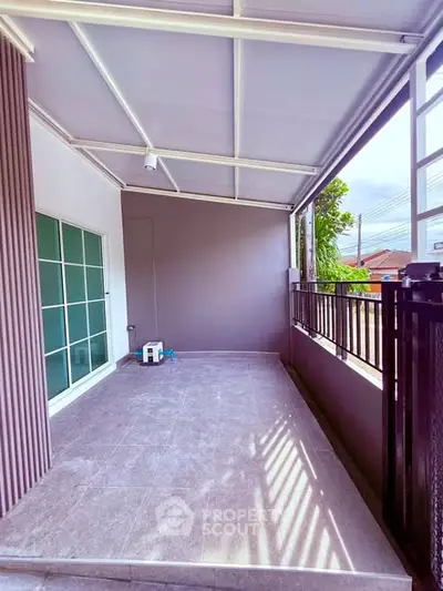 Spacious covered balcony with modern design and natural light.