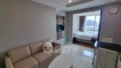 Modern apartment interior with cozy living room and bedroom view, featuring sleek furniture and cityscape window.