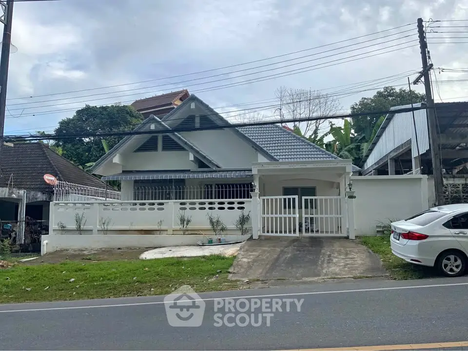 Charming single-story house with modern roof and gated driveway in a serene neighborhood.