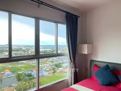 Stunning bedroom with panoramic city and sea views, featuring modern decor and large windows.