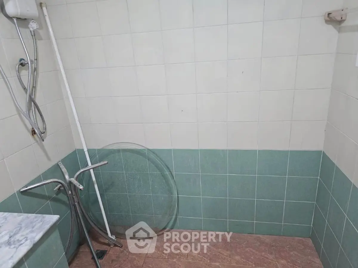 Simple bathroom with tiled walls and shower area