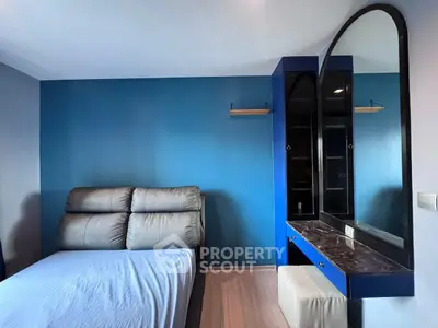 Modern bedroom with blue accent wall and stylish vanity mirror