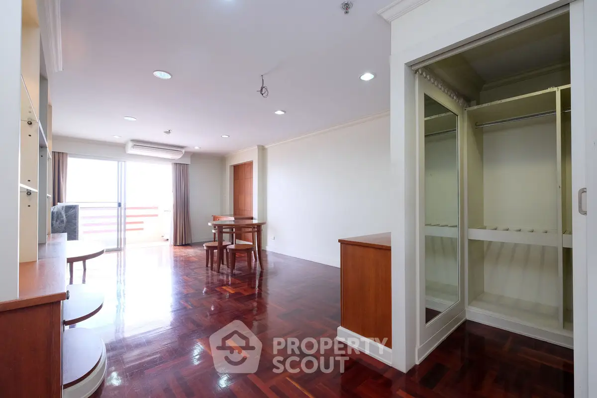 Spacious living room with wooden flooring and open balcony access