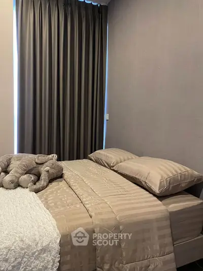 Cozy bedroom with elegant decor and plush elephant toy on bed