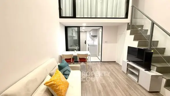 Modern loft-style living room with open kitchen and stylish staircase