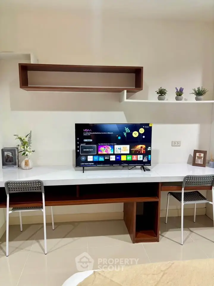 Modern living room with sleek TV setup and stylish shelving, perfect for entertainment and relaxation.