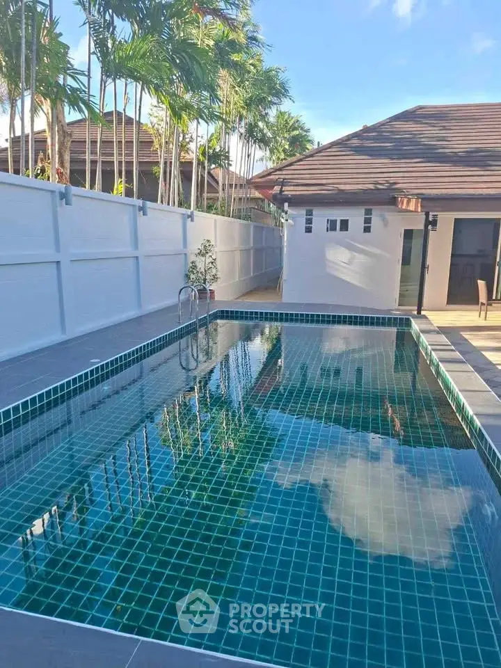 Stunning private pool area with modern tiles and lush greenery, perfect for relaxation and entertainment.