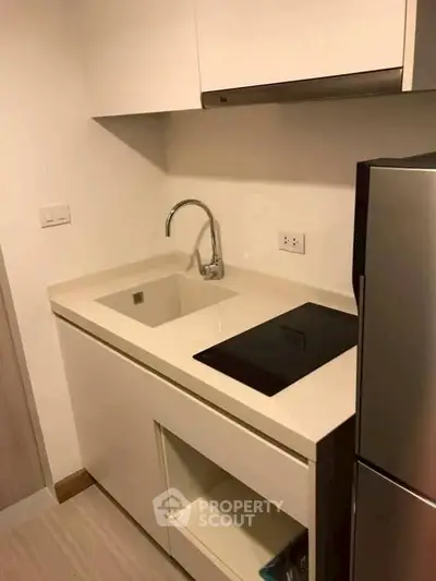 Modern kitchen with sleek countertop and built-in appliances in a compact layout.