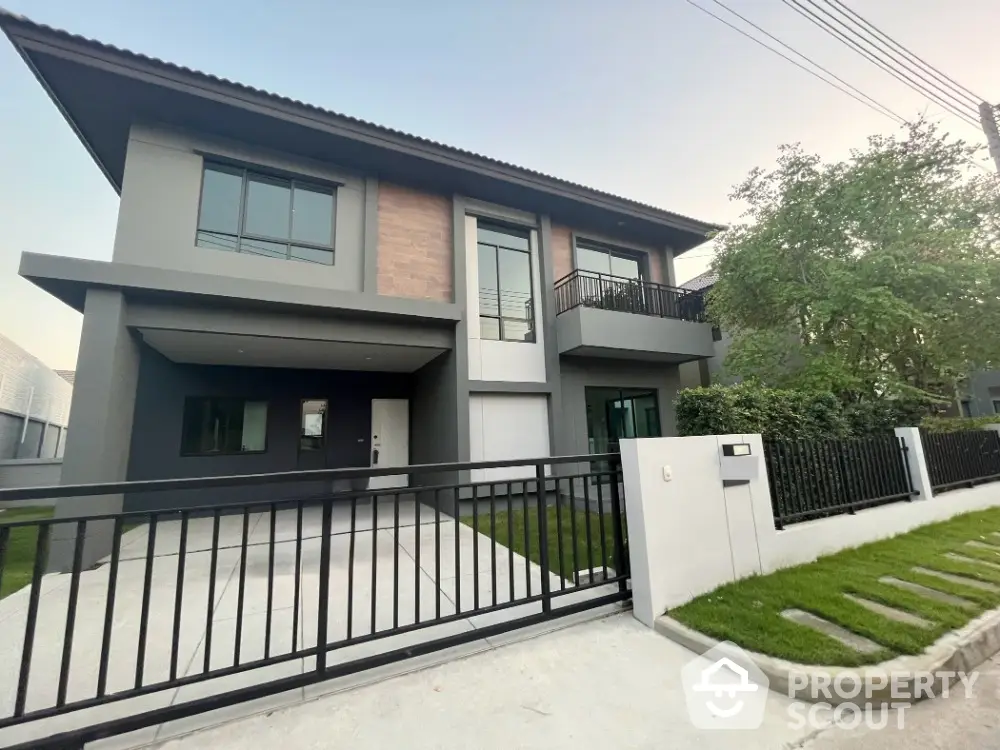 Modern two-story house with sleek design and spacious driveway in a serene neighborhood.