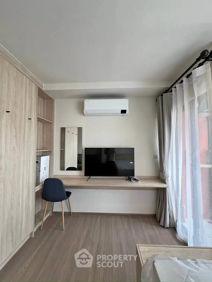 Modern living room with TV, air conditioning, and stylish wooden furniture