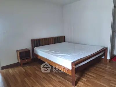 Spacious bedroom with wooden flooring and modern bed frame