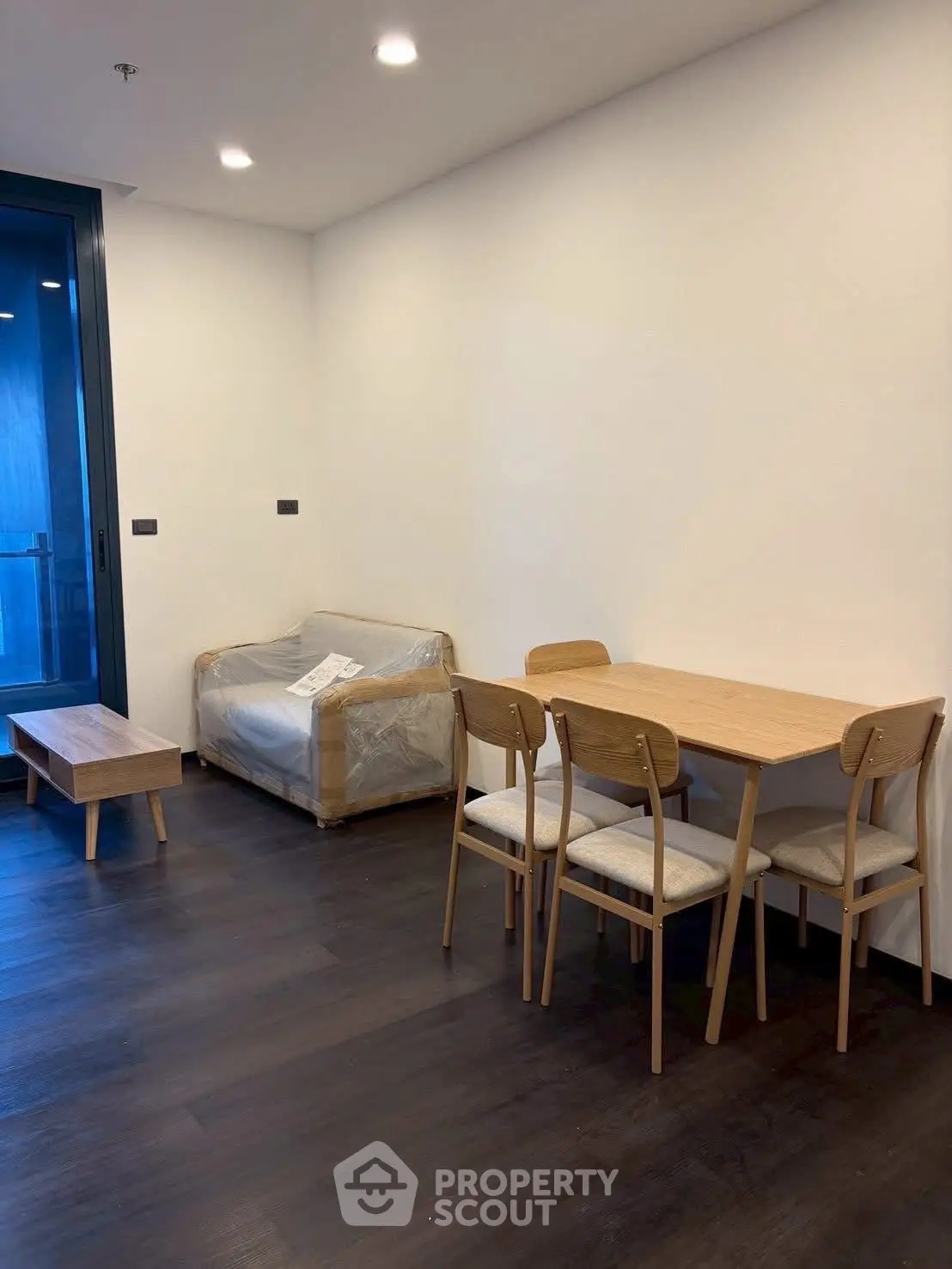 Modern living room with minimalist furniture and dark wood flooring