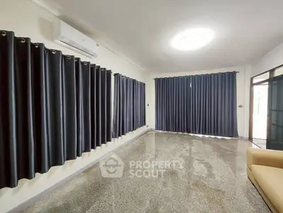 Spacious living room with polished floors and large windows, ideal for modern living.