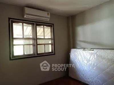 Cozy room with air conditioning and natural light through wooden windows.