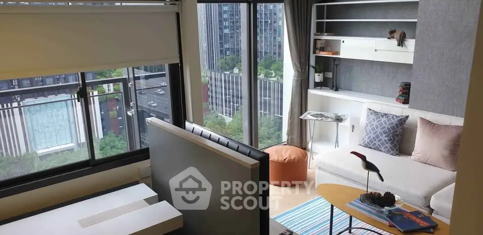 Modern living room with city view, stylish decor, and ample natural light.