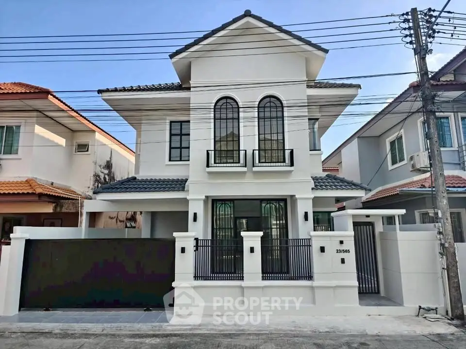 Elegant two-story white house with modern design and gated entrance in a suburban neighborhood.