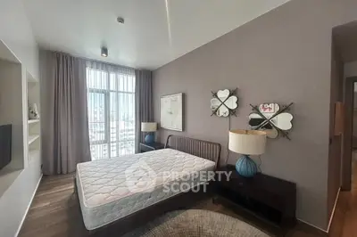 Spacious bedroom with large window and stylish decor in modern apartment