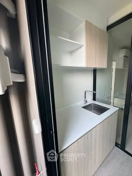 Compact modern kitchen with sleek cabinetry and stainless steel sink