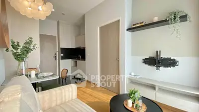 Modern living room with open kitchen, stylish decor, and natural light in a cozy apartment.