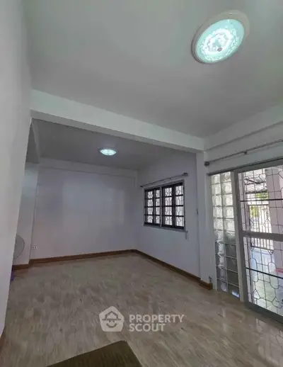 Spacious empty room with large windows and glass door, ideal for customization.