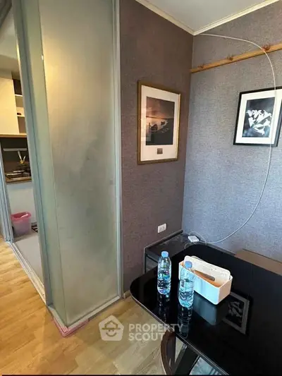 Modern apartment interior with sleek kitchen and dining area, featuring stylish decor and wooden flooring.