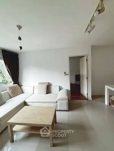 Spacious living room with modern white sofa and natural light