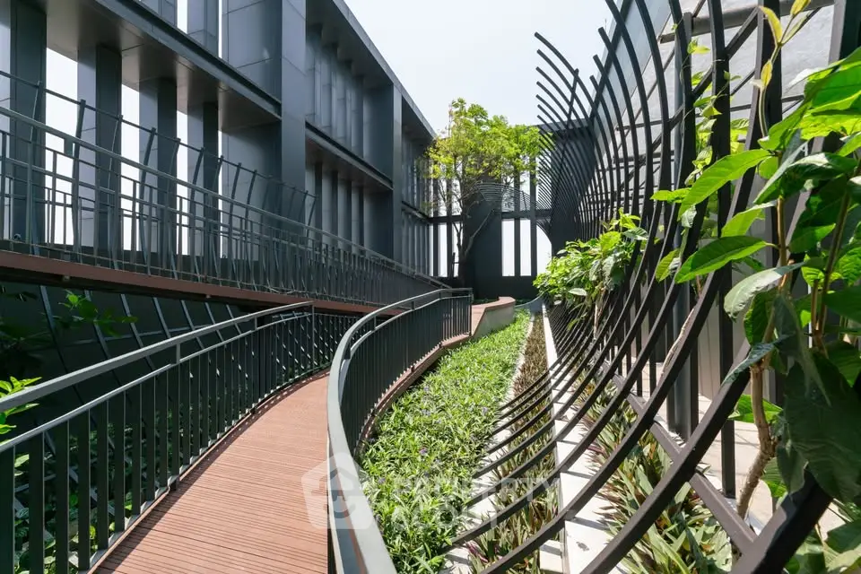 Modern architectural exterior with lush greenery and sleek metal design.