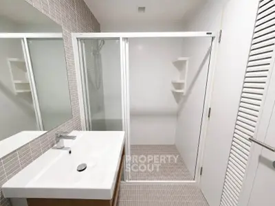 Modern bathroom with sleek shower and stylish sink in contemporary design.