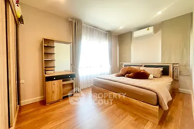 Spacious bedroom with wooden flooring and modern furnishings in a cozy apartment