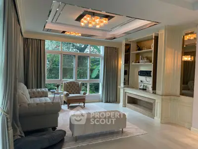 Luxurious living room with elegant furniture and large windows overlooking a lush garden.