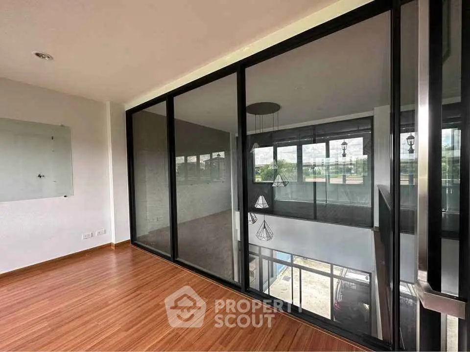 Spacious modern living area with floor-to-ceiling windows and elegant lighting fixtures.