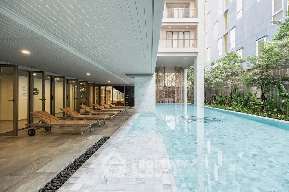 Luxurious apartment complex with stunning pool and relaxing lounge area.
