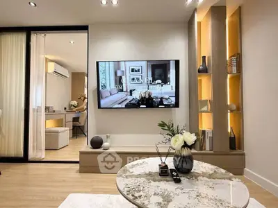 Modern living room with stylish decor and large TV, featuring elegant lighting and cozy seating area.