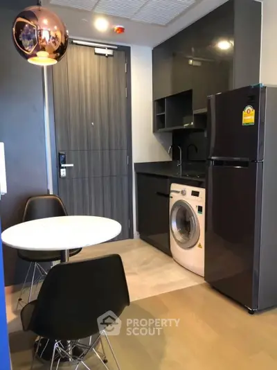 Modern compact kitchen with washing machine and fridge in sleek apartment