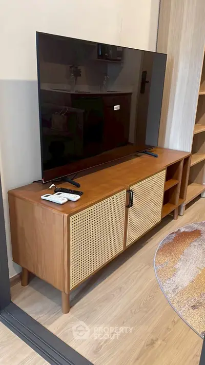 Modern living room with sleek TV stand and large flat-screen TV, perfect for entertainment.