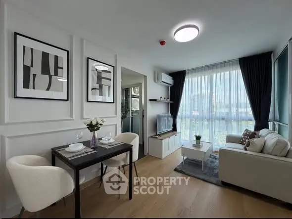 Modern living room with elegant decor and large windows offering natural light.