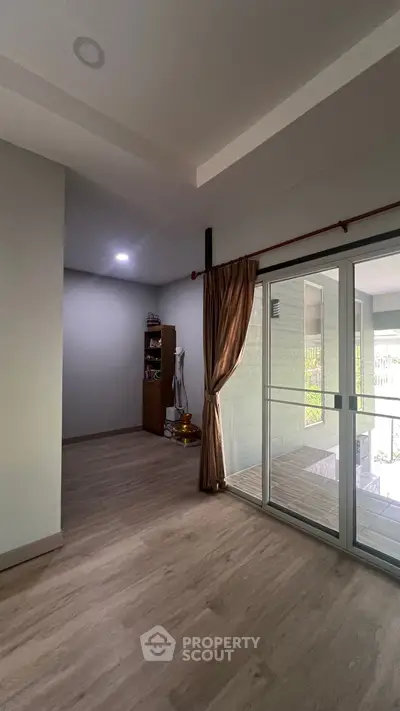 Spacious interior with sliding glass doors and wooden flooring, ideal for modern living.