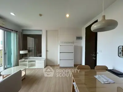 Modern living room with wooden flooring, stylish furniture, and ample natural light.