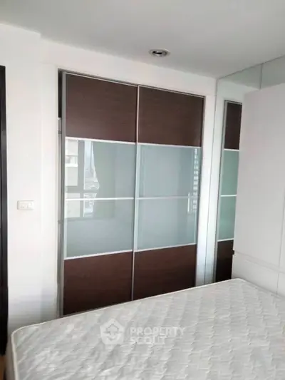 Modern bedroom with sleek sliding wardrobe and comfortable mattress