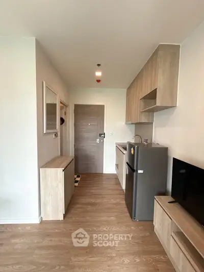 Modern apartment interior with compact kitchen and stylish wooden flooring