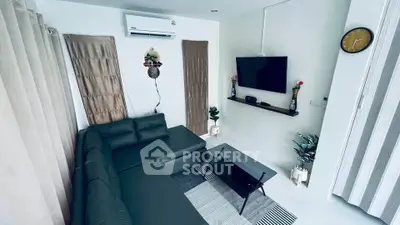 Modern living room with sleek black sofa and wall-mounted TV