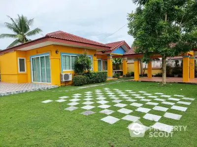 Charming yellow house with red roof and spacious green lawn