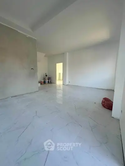 Spacious unfurnished room with marble flooring and natural light