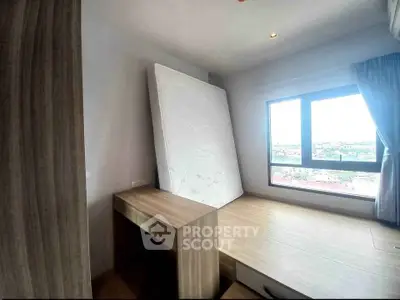 Modern bedroom with large window and built-in wooden furniture, offering a bright and airy atmosphere.