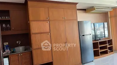 Spacious living area with built-in wooden cabinets and modern appliances