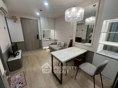 Modern living room with elegant chandelier and stylish furniture in a cozy apartment.